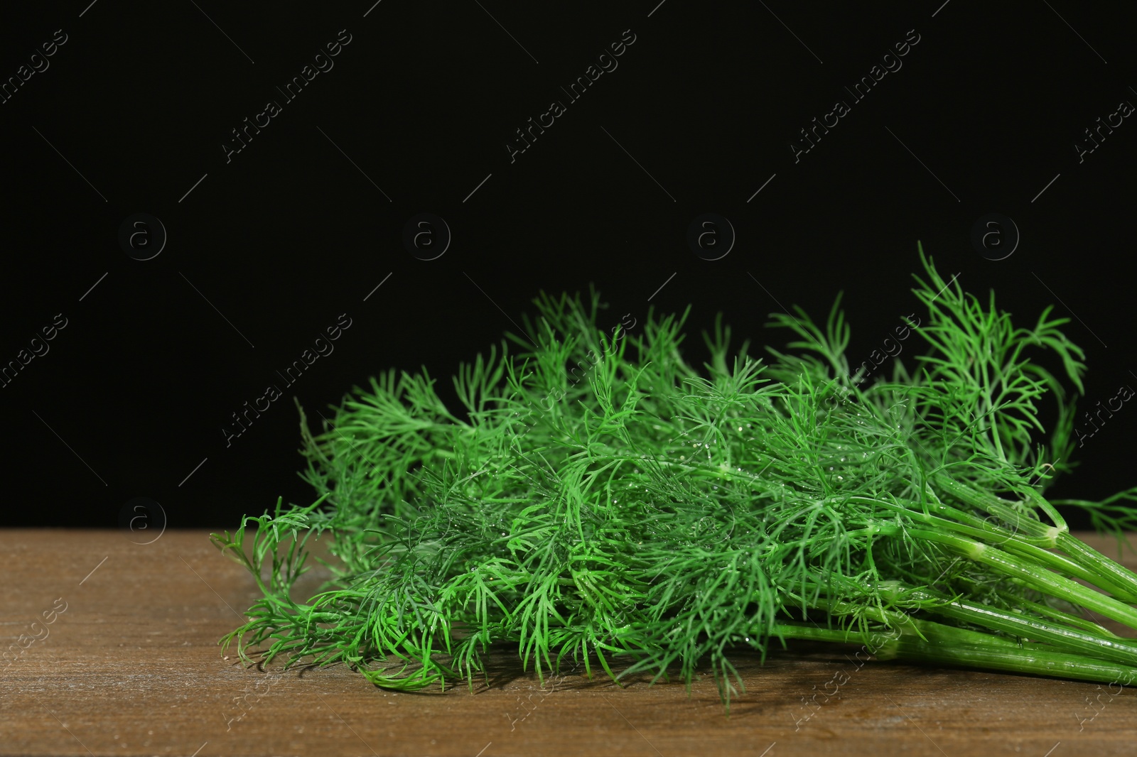 Photo of Fresh green dill on wooden table, closeup. Space for text