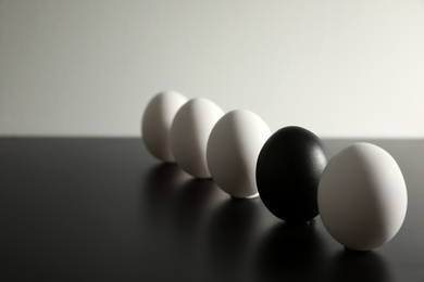 Photo of Black egg among others on table. Space for text