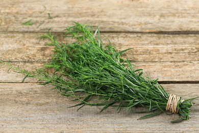 Photo of Bunch of fresh tarragon on wooden table