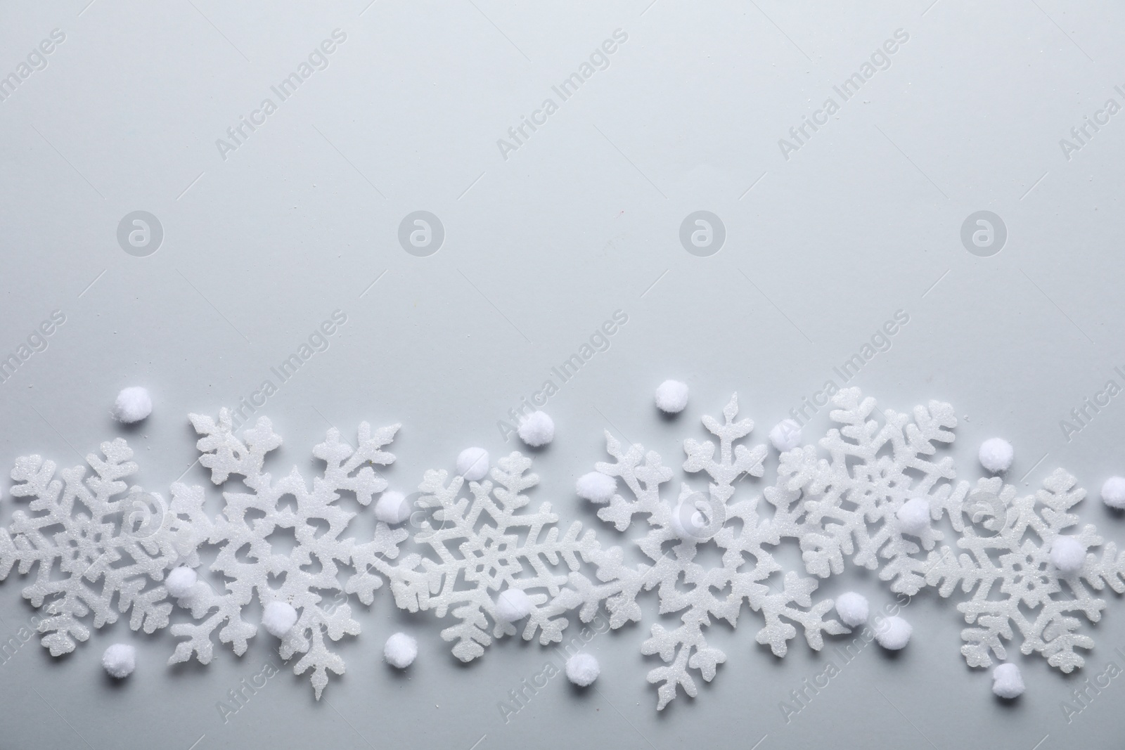 Photo of Beautiful snowflakes and decorative balls on white background, flat lay. Space for text