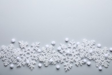 Beautiful snowflakes and decorative balls on white background, flat lay. Space for text