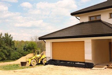 Photo of Modern loader near house on sunny day