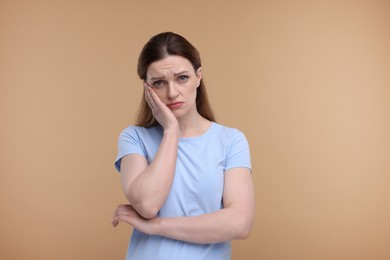 Photo of Portrait of sad woman on beige background