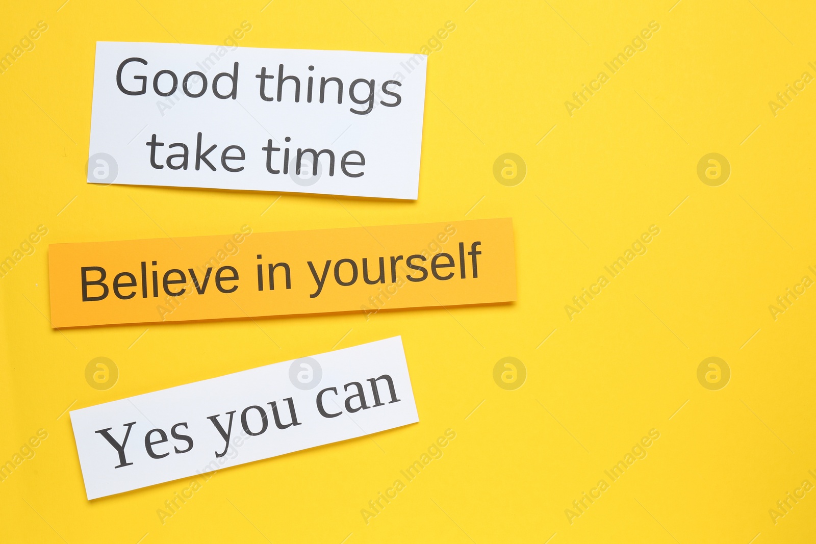 Photo of Notes with motivational quotes on yellow background, flat lay. Space for text