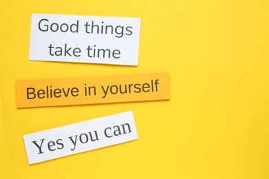 Photo of Notes with motivational quotes on yellow background, flat lay. Space for text