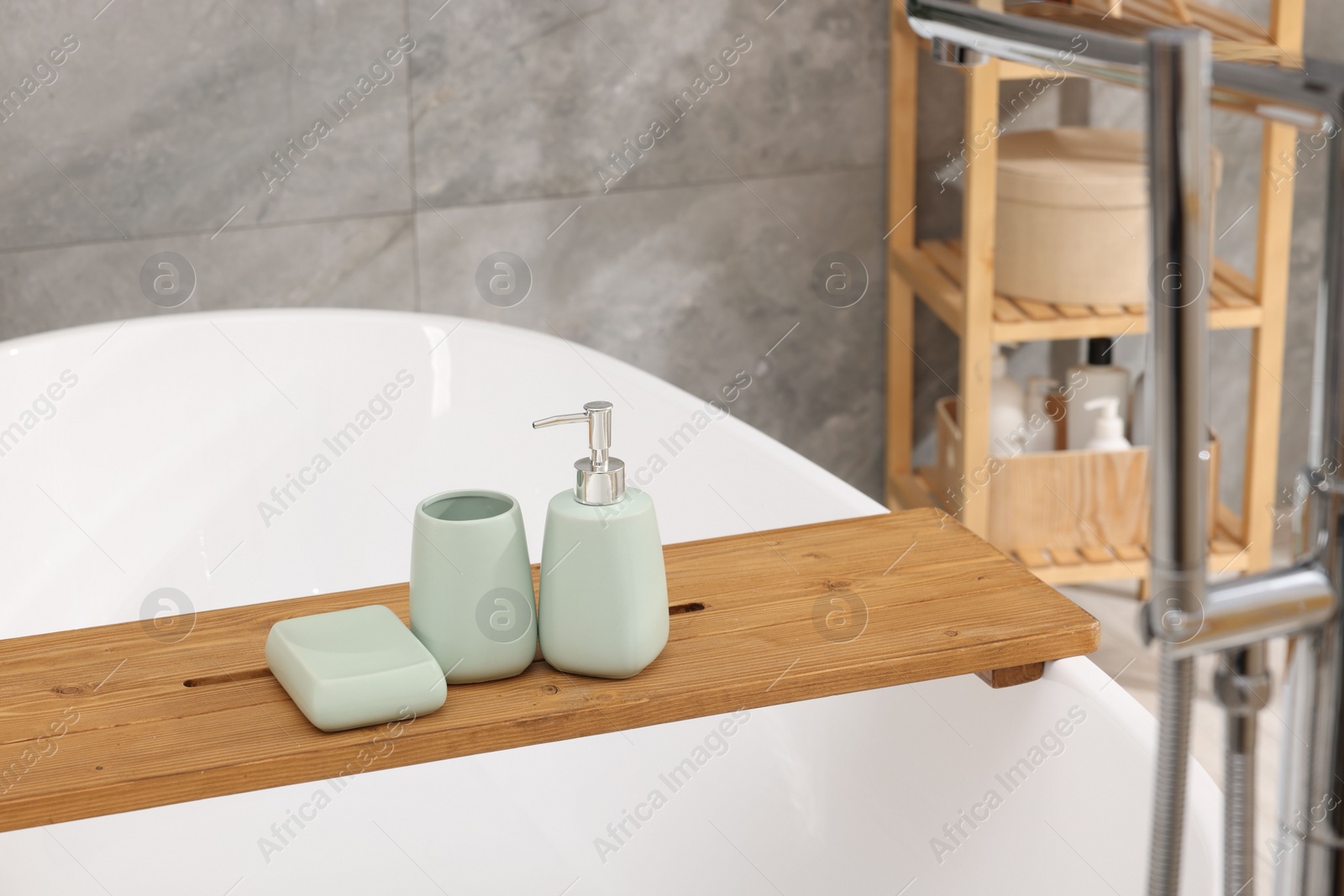 Photo of Set of bath accessories on tub in bathroom