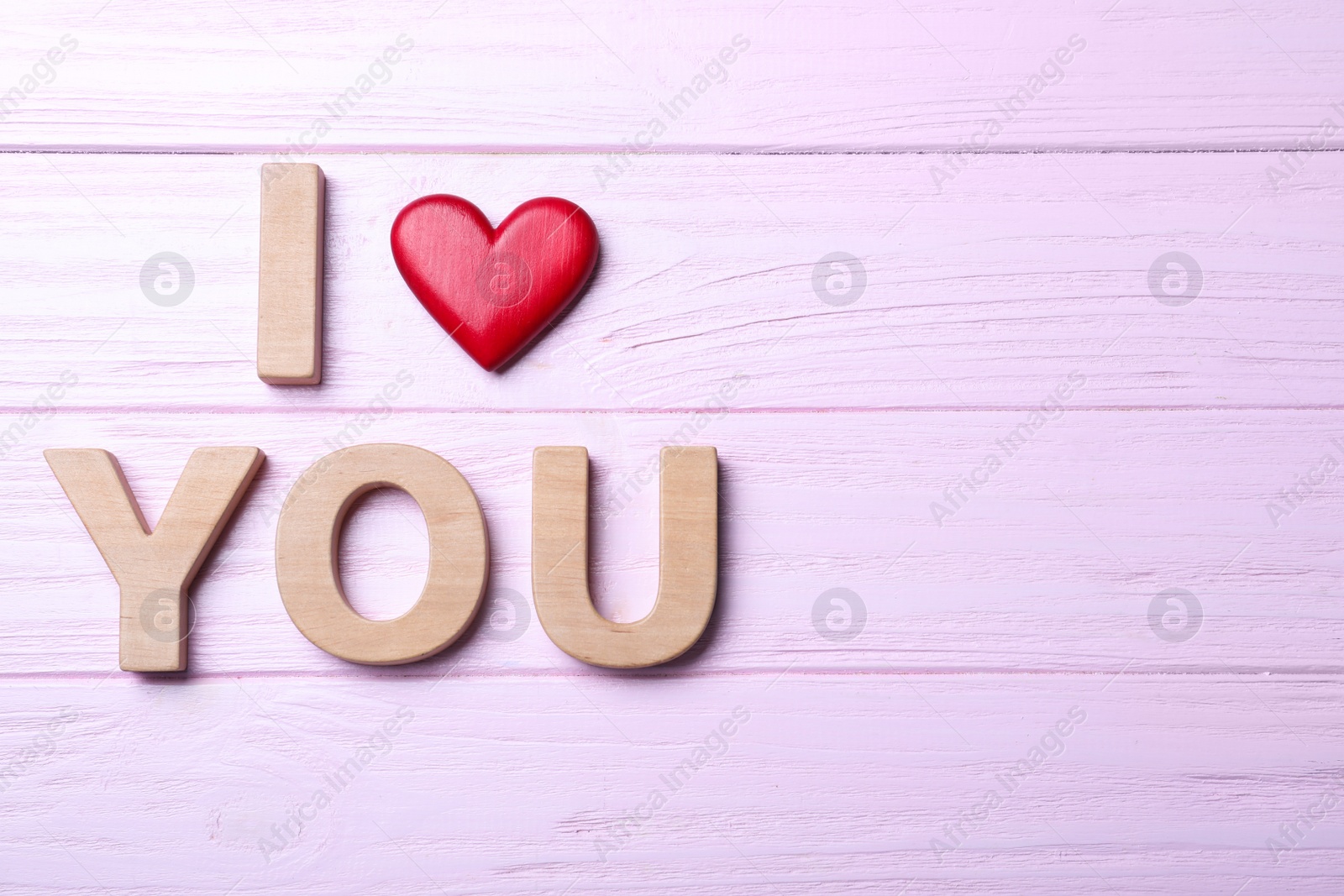 Photo of Phrase I Love You made of decorative heart and letters on pink wooden background, flat lay. Space for text