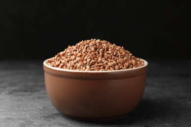 Photo of Buckwheat grains on grey table against black background