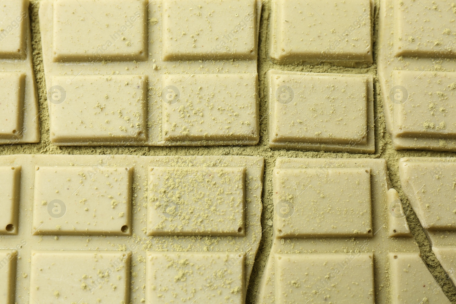 Photo of Pieces of tasty matcha chocolate bar and powder, top view