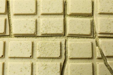Photo of Pieces of tasty matcha chocolate bar and powder, top view