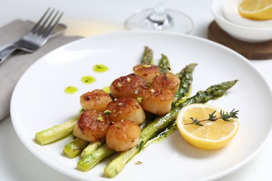 Photo of Delicious fried scallops with asparagus, lemon and thyme served on white table, closeup