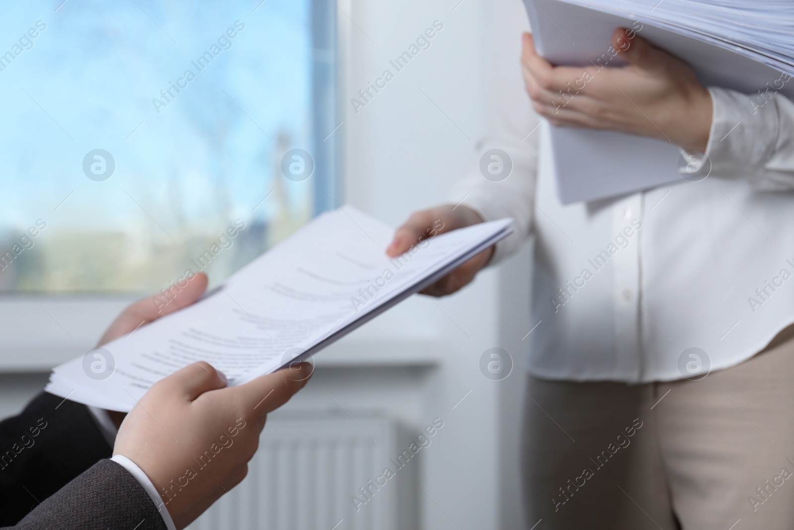Photo of Woman giving many documents to man in office, closeup