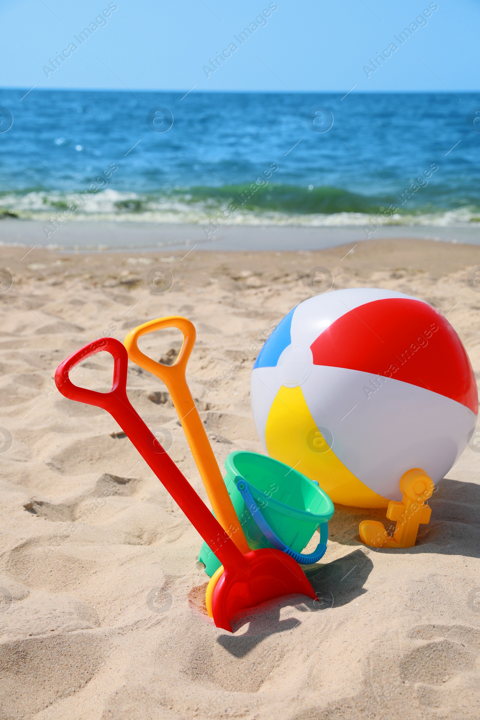 Photo of Different sand toys and beach ball near sea