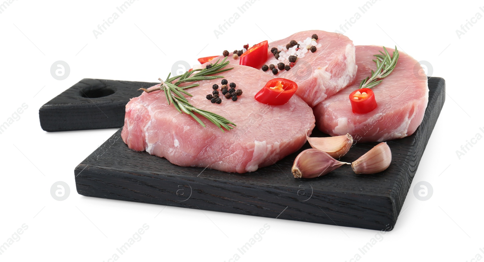 Photo of Black wooden board with pieces of raw pork meat and spices isolated on white