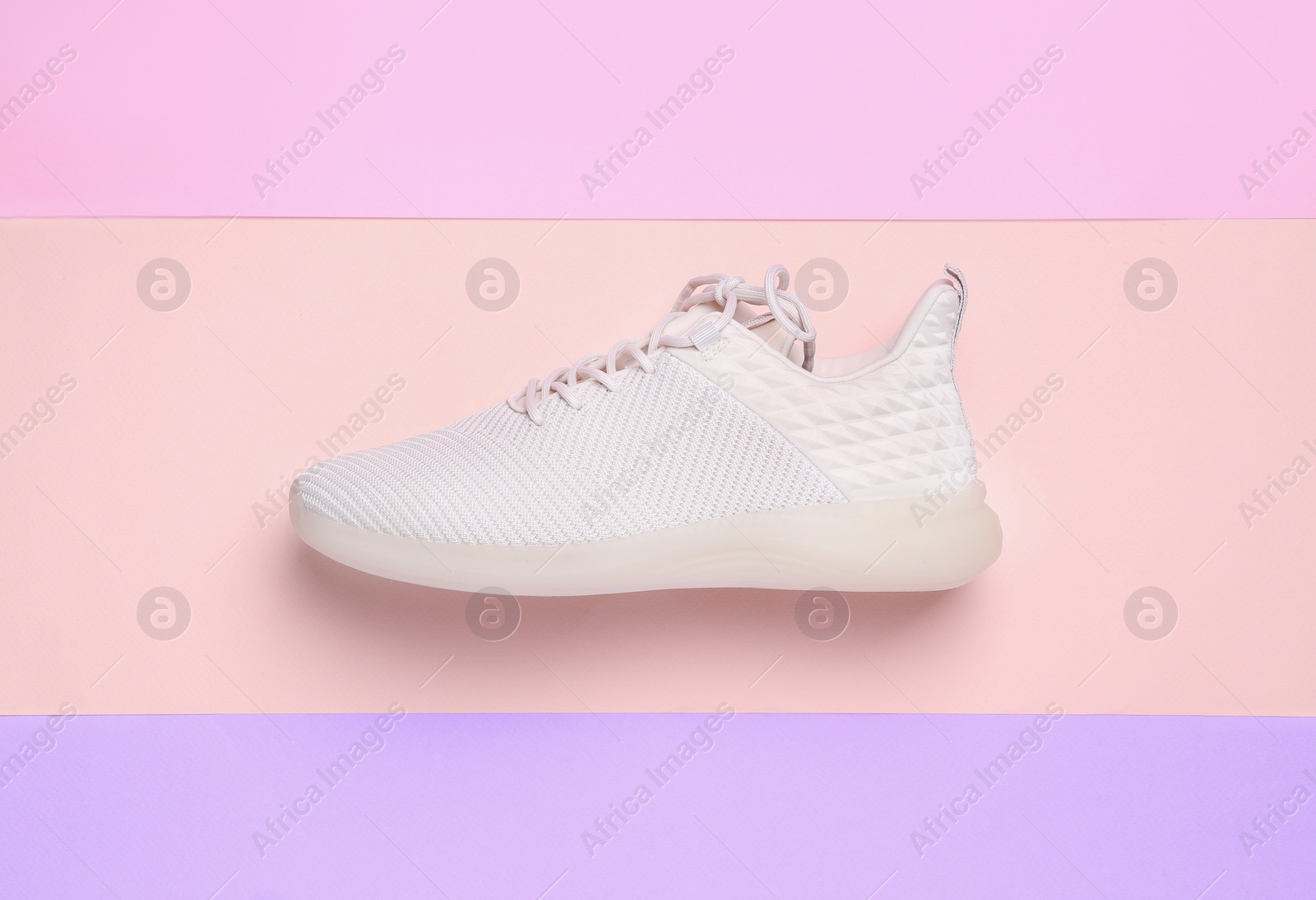 Photo of Stylish sporty sneaker on color background, top view