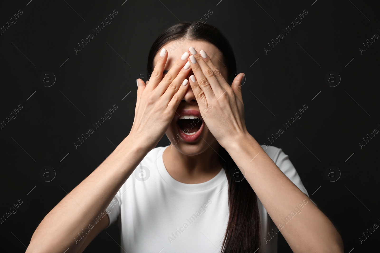 Photo of Young woman feeling fear on black background