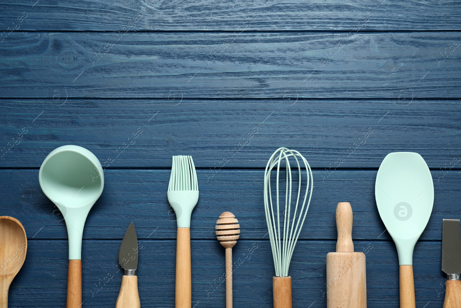 Photo of Set of different kitchen utensils on blue wooden table, flat lay. Space for text