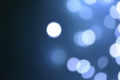 Photo of Blurred view of beautiful lights on blue background, space for text