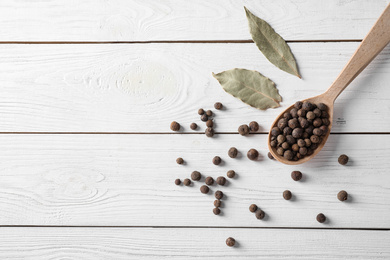 Photo of Flat lay composition with black pepper on white wooden table, space for text