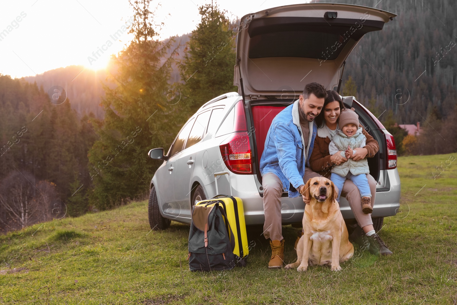 Photo of Parents, their daughter and dog near car in mountains, space for text. Family traveling with pet