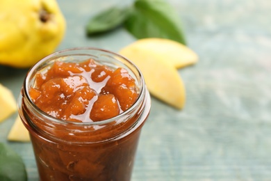 Delicious quince jam and fruits on blue wooden table, closeup. Space for text