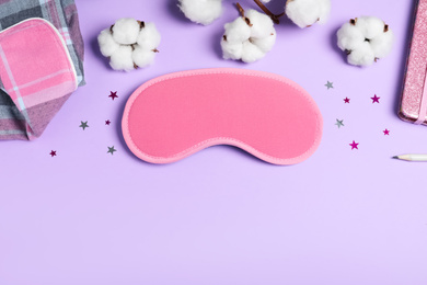 Photo of Flat lay composition with sleeping mask on violet background, space for text. Bedtime accessory