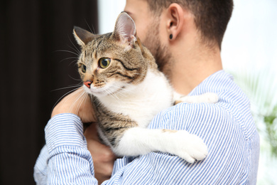 Photo of Man with cat at home. Friendly pet