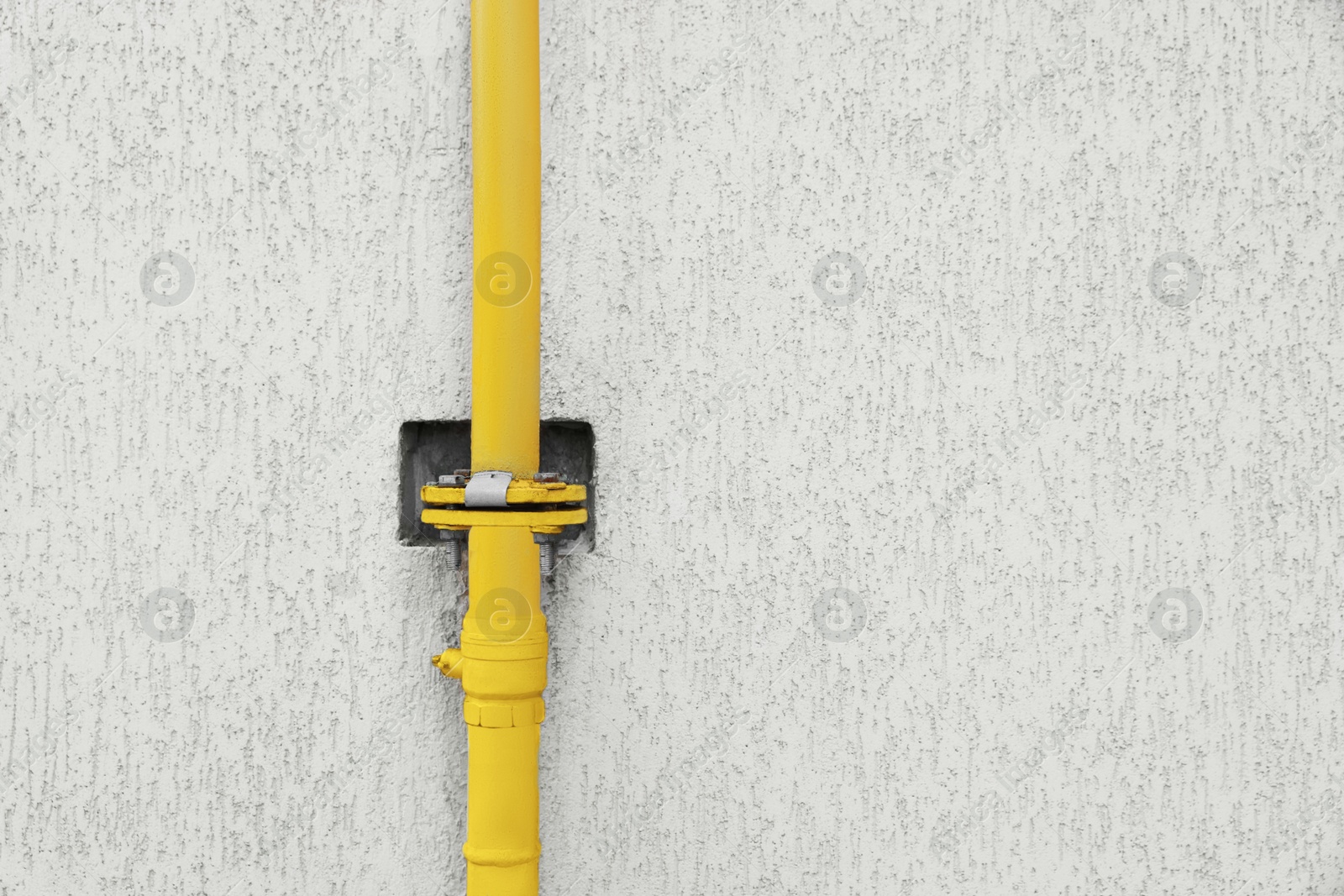 Photo of Yellow gas pipe near beige wall outdoors, space for text