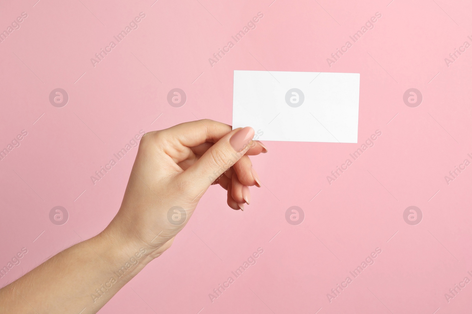 Photo of Woman holding blank business card on pink background, closeup. Mockup for design