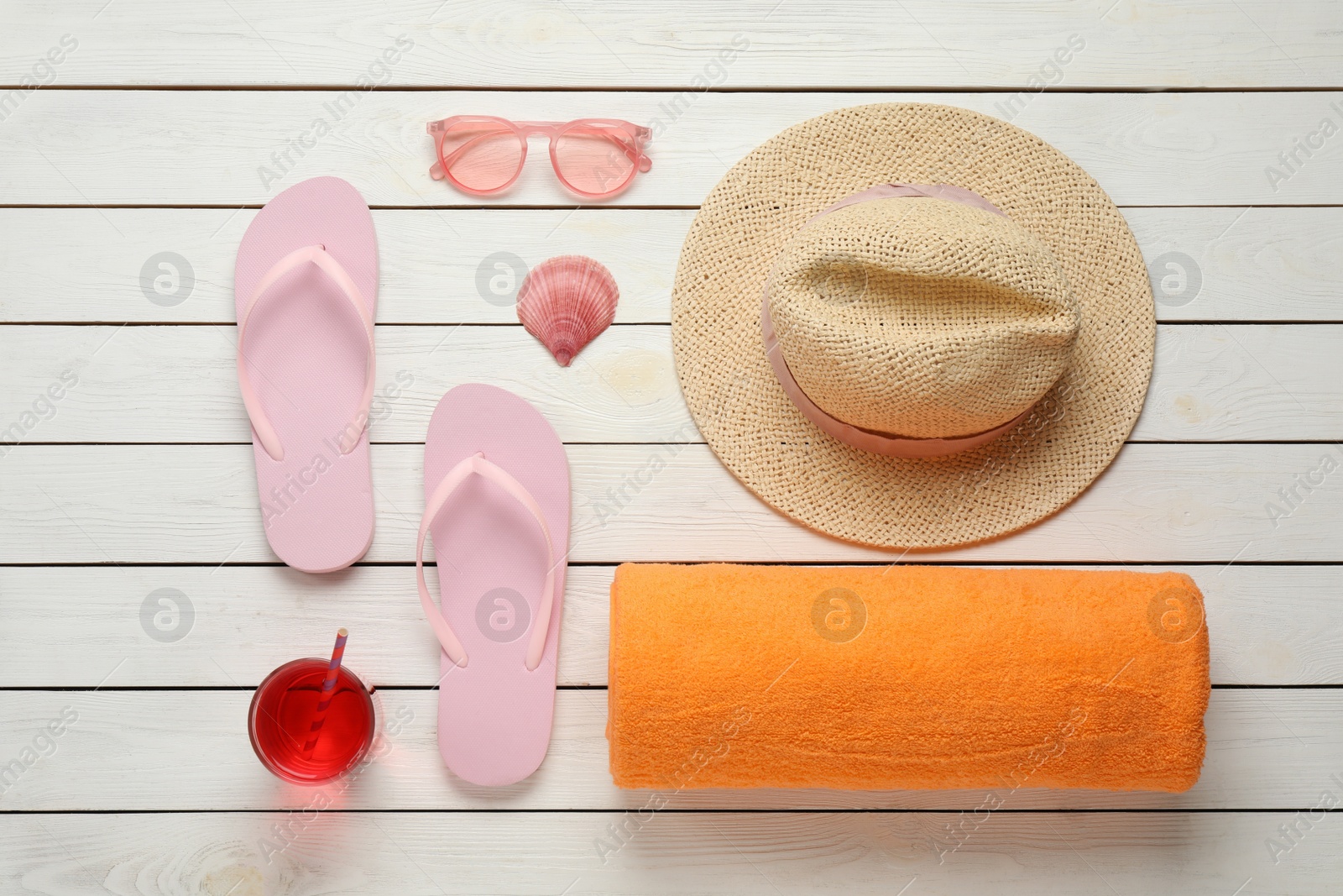 Photo of Beach towel, flip flops, sunglasses, cocktail and hat on white wooden background, flat lay