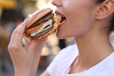 Photo of Lviv, Ukraine - September 26, 2023: Woman eating McDonald's burger outdoors, closeup