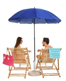 Photo of Young couple with beach accessories on sun loungers against white background