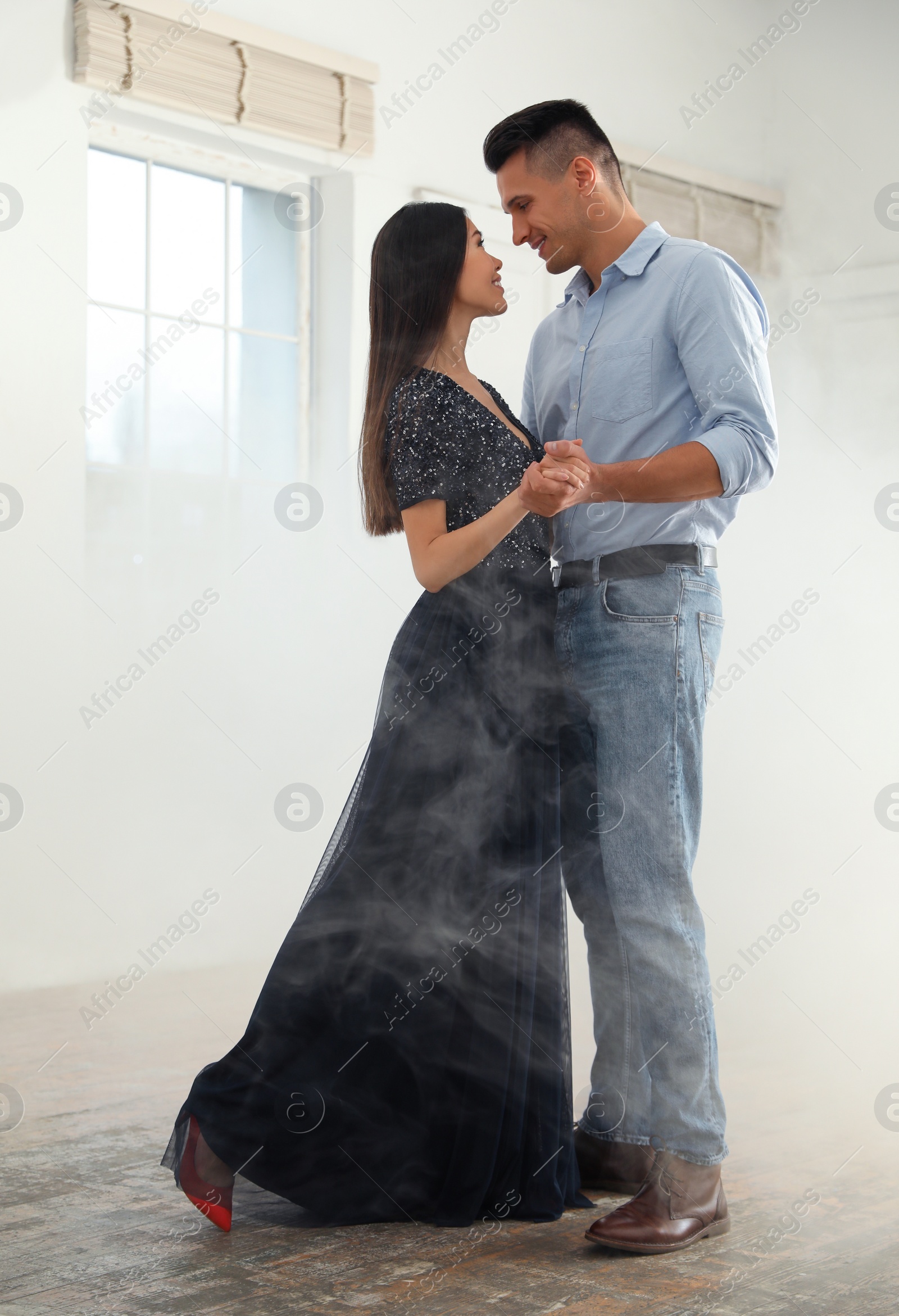 Photo of Lovely young couple dancing together in ballroom