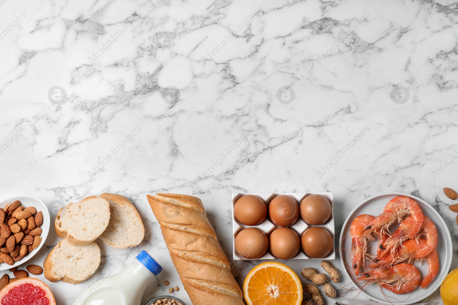 Photo of Flat lay composition of different products and space for text on white marble table. Food allergy concept