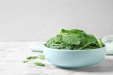 Fresh green healthy spinach on white marble table. Space for text