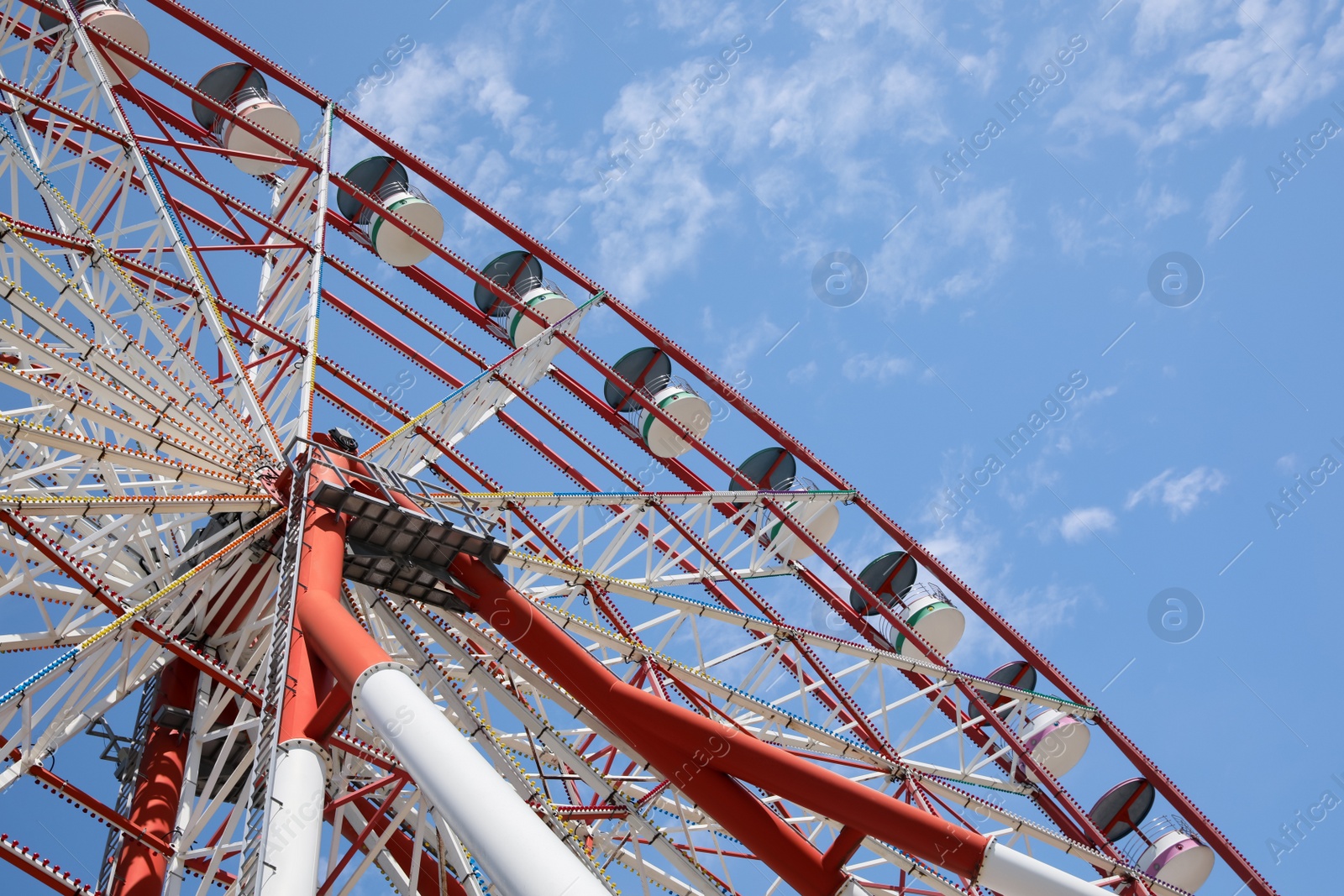 Photo of Beautiful large Ferris wheel against blue sky, low angle view