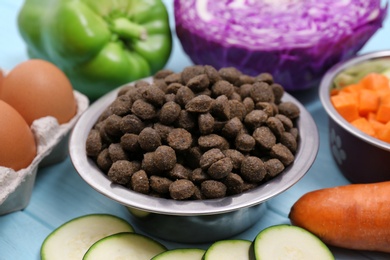 Photo of Composition with dry and natural dog food on table