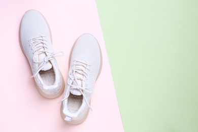 Photo of Stylish sporty sneakers on color background, top view. Space for text