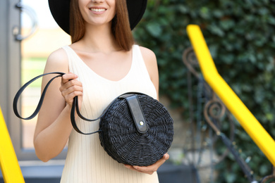 Photo of Beautiful young woman with stylish handbag outdoors on summer day