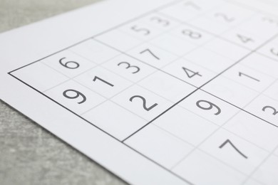 Photo of Sudoku puzzle on grey table, closeup view