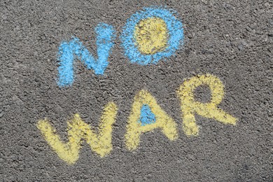 Words No War written with blue and yellow chalks on asphalt outdoors, top view