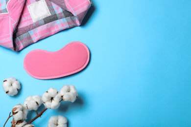 Photo of Flat lay composition with sleeping mask on light blue background, space for text. Bedtime accessories