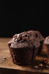 Photo of Delicious chocolate muffin on wooden table, closeup. Space for text