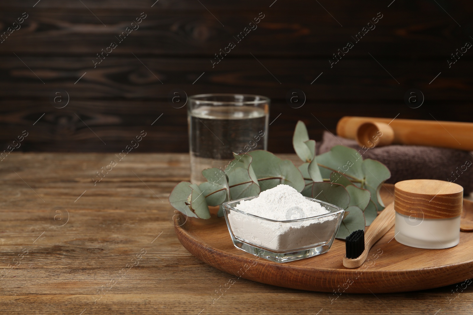 Photo of Composition with tooth powder and eucalyptus on wooden table, space for text