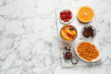 Photo of Immunity boosting drink and ingredients on white marble table, top view. Space for text