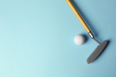 Photo of Golf ball and club on light blue background, flat lay. Space for text