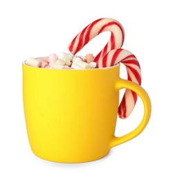 Photo of Cup of tasty cocoa with marshmallows and Christmas candy canes isolated on white