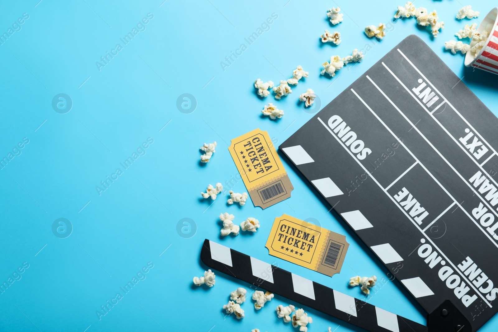 Photo of Flat lay composition with cinema tickets and clapperboard on light blue background, space for text