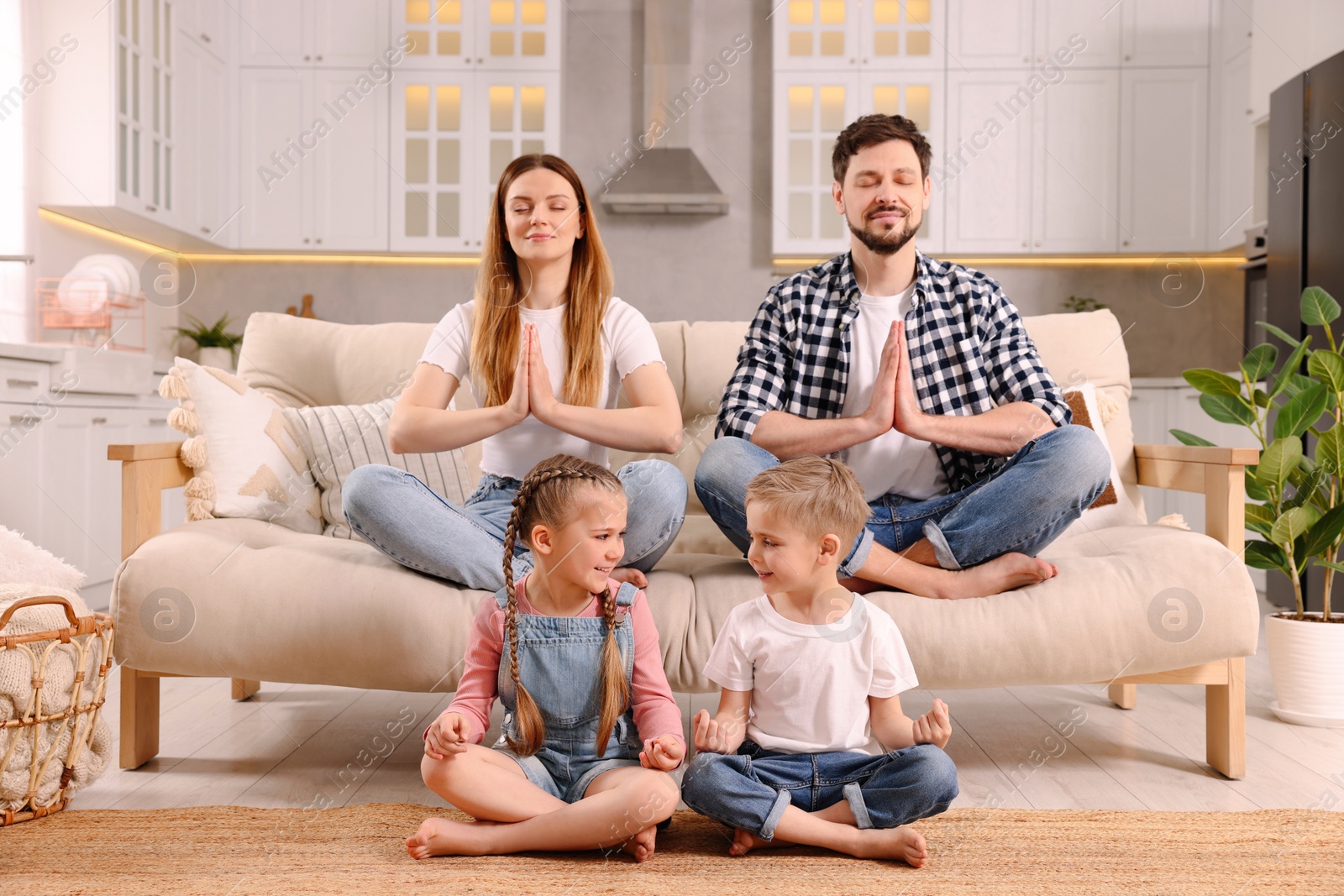 Photo of Family meditating together at home. Harmony and zen