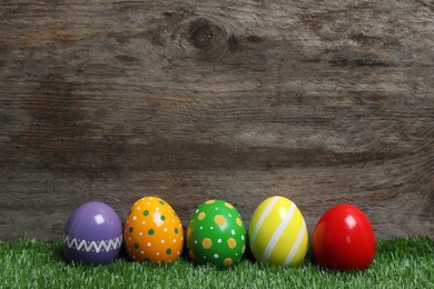 Decorated Easter eggs on green grass. Space for text